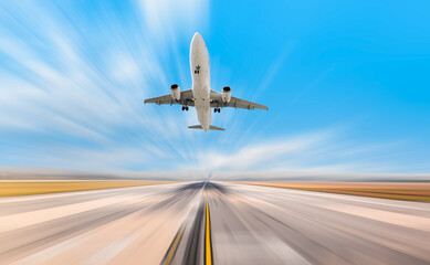 Fototapeta na wymiar Airplane in motion- White Passenger plane fly up over take-off runway from airport 