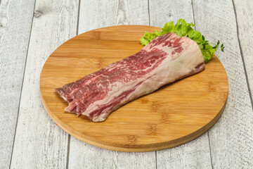 Raw beef bacon over wooden board