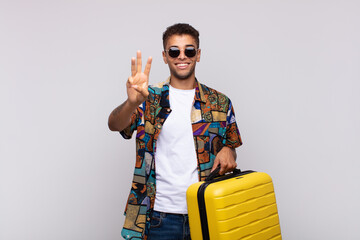 young south american man smiling and looking friendly, showing number three or third with hand...
