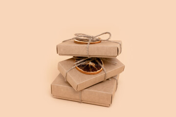 Pile of gift boxes on a beige background. Christmas preparation minimalistic concept.