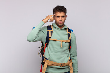 young hiker man feeling confused and puzzled, showing you are insane, crazy or out of your mind