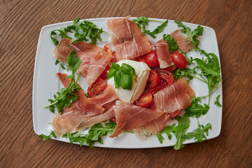 Plate of ham with mozarella and salad