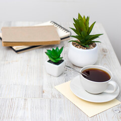 desk office with blank notepad, coffee cup and pen on wood table.