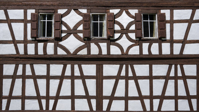 Fachwerk Fassade eines Modellbau Hauses mit drei Fenstern, teils stark verwittert