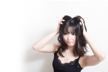 Naklejka premium 何かに困って髪を乱している日本人の女性