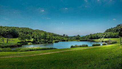 Panorama of Ljeskove vode lake. Green forest and blue sky in the background. Picnic area near Slavonski Brod, Croatia.