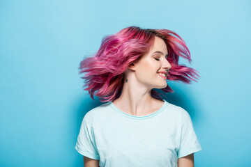 young woman waving pink hair on blue background