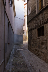 Around a corner and down a medieval street in an ancient Spanish town on sunny day
