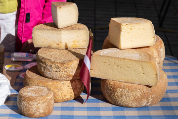 Variety homemade bio natural cheese in a street food market in Latvia, with Latvian flag