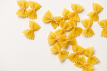 Farfalle - one of types of traditional Italian pasta. Macaroni products are randomly scattered on a white background,  for advertising, blogging, cooking recipes, packaging