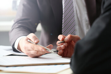 Male arm in suit and tie fill form clipped pad with silver pen closeup. Sign gesture read pact sale...