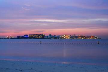 Sunset on the seashore with the lights of the city in the distance