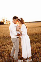 Portrait of beautiful family with little daughter, handsome father hold cute newborn baby girl in arms, gorgeous parents enjoy tender moments, parenthood and childhood concept