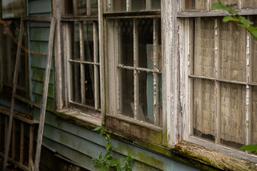 Fototapeta na wymiar Weatherd window on an abandoned house