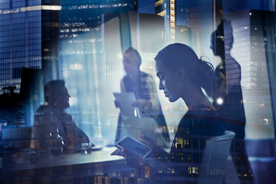 Businesswoman using digital tablet in highrise office meeting