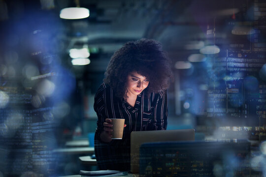 Businesswoman working late at laptop with coffee