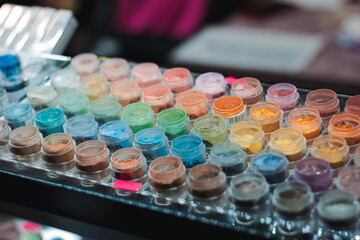 Mineral eyeshadow. Many jars with multi-colored eyeshadows. Exhibition of cosmetics