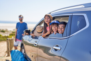 Portrait happy family in car at sunny  beach