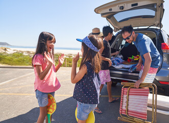 Happy sisters playing clapping game in sunny beach parking lot