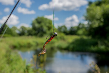silicone fishing bait/silicone fishing bait on a fishing line against the background of the river