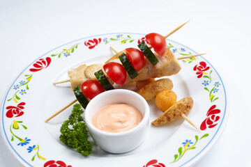 chicken kebab with sauce and vegetables