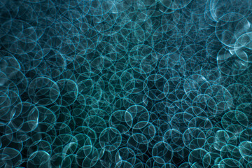 Green and blue bokeh circles in manual focus on the light source and water highlights. Large space for an elegant and delicate design background