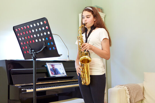 Girl taking online saxophone lesson at home