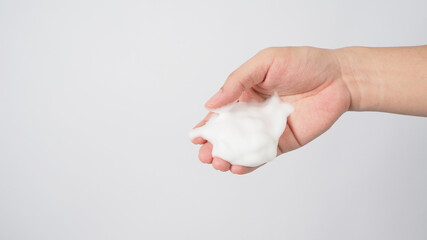 Hand with foaming hand soap for washing on white background.