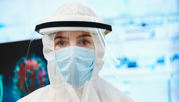Portrait confident female scientist in clean suit studying coronavirus
