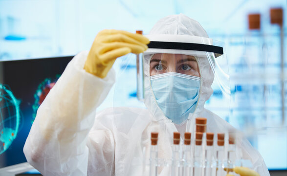 Female scientist in clean suit researching coronavirus vaccine