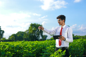 young indian handsome agronomist with test tube and tablet