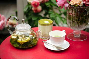 Morning summer tea set in the garden on a red table