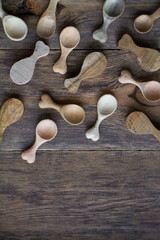 Handmade wooden utensils, top view lot of billets and spoons on wooden table, selective focus