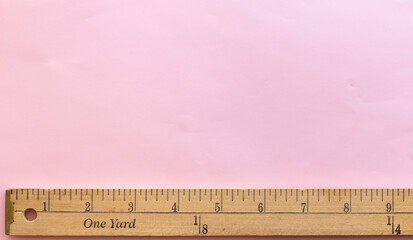 Yardstick placed on the bottom of the image with light pink space on top for something to be...