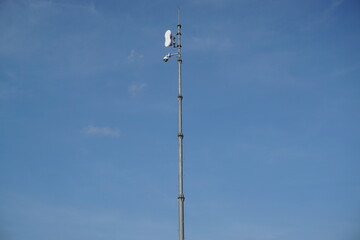 Wifi signal transmitter photo, with outdoor background under blue sky.