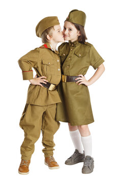 Little boy kissing smiling girl isolated at white background. Concept of children friendship. Russsian vintage military uniform.