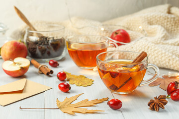 Two cups of fragrant tea with rosehip, lemon and spices. A healthy drink to strengthen the immune system. On a light wooden background, close-up