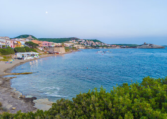 Fototapeta na wymiar S'Archittu (Italy) - The little arch, in the Sardinian language, is a small coastal touristic town in province of Oristano, Sardinia region and island. Here a view at sunset.