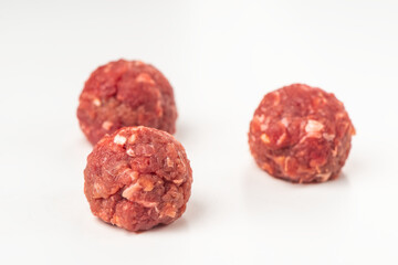 Raw beef meatballs on white background