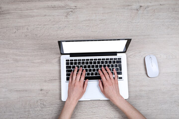 Female hands typing on laptop keyboard with mouse on white background