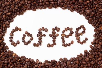 The word coffee is laid out from coffee beans. Roasted coffee beans collected the word coffee. Beans on white background.