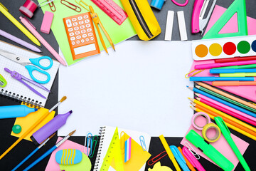 Different school supplies with blank sheet of paper on black background