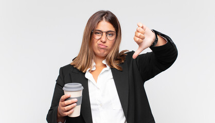 young businesswoman with a coffee feeling cross, angry, annoyed, disappointed or displeased, showing thumbs down with a serious look © kues1