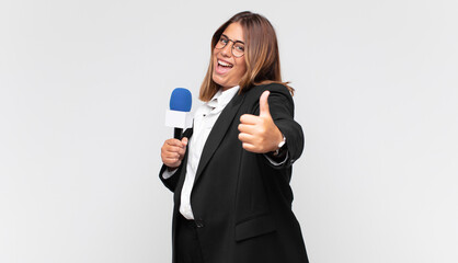 young woman reporter feeling proud, carefree, confident and happy, smiling positively with thumbs up