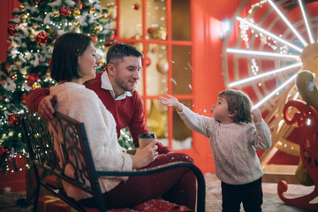 Obraz premium Family with a child near a New Year tree in Christmas decorations