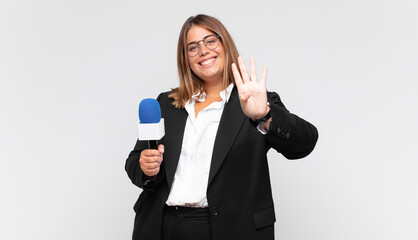 young woman reporter smiling and looking friendly, showing number four or fourth with hand forward,...