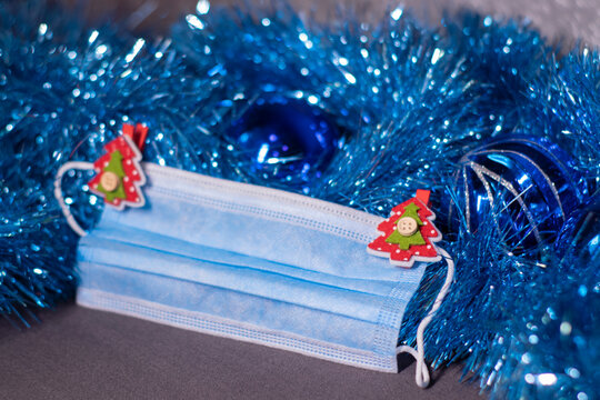 blue medical mask with christmas tree-shaped clothespins. new years medical flatly photo.
