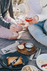 Fototapeta na wymiar Two women female friends having picnic brunch with fresh homemade food and champagne.