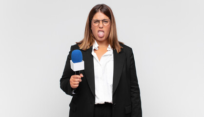 young woman reporter feeling disgusted and irritated, sticking tongue out, disliking something...