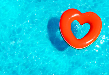 Inflatable red heart buoy swim in the swimming pool view from above